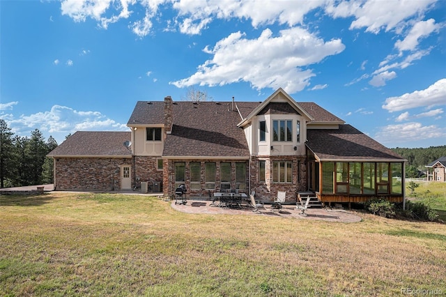 rear view of property with a sunroom, a patio, and a lawn