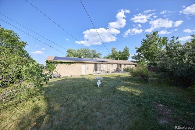 6579 S Lincoln St, Centennial, CO 80121 - back of property with roof mounted solar panels, a lawn, and a patio area