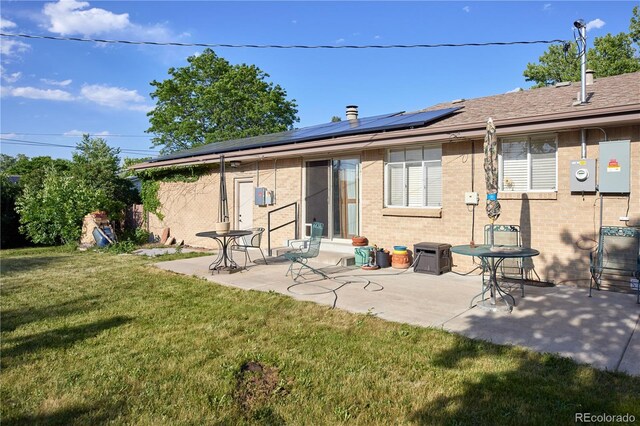 6579 S Lincoln St, Centennial, CO 80121 - rear view of house with a lawn, solar panels, brick siding, and a patio