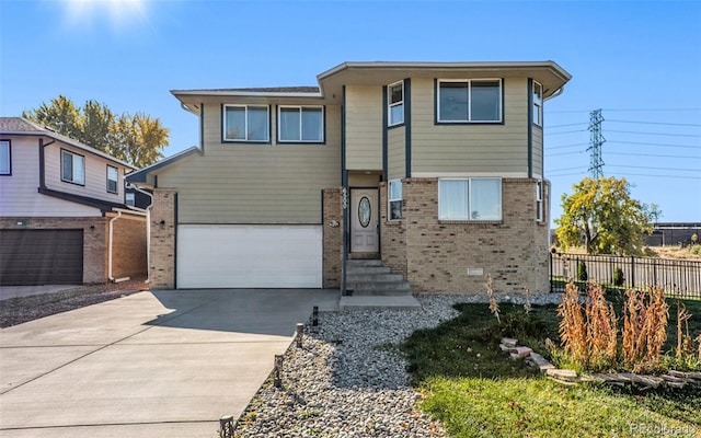 view of front of property featuring an attached garage, brick siding, fence, driveway, and crawl space