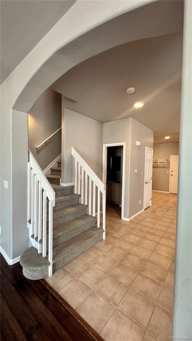 1254 Carlyle Park Cir, Highlands Ranch, CO 80129 - stairs with arched walkways, tile patterned floors, and recessed lighting