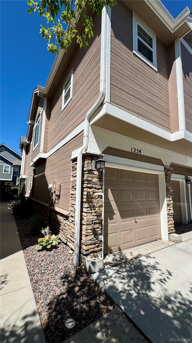 1254 Carlyle Park Cir, Highlands Ranch, CO 80129 - view of property exterior featuring stone siding and an attached garage