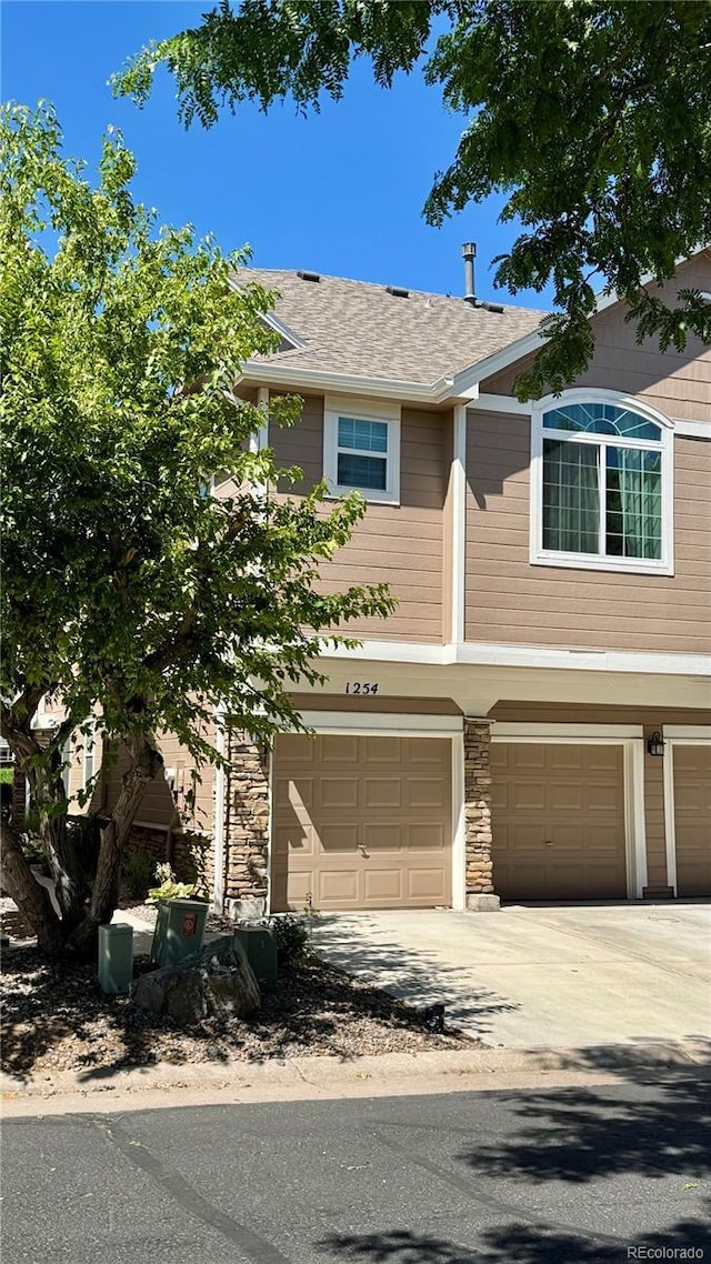 1254 Carlyle Park Cir, Highlands Ranch, CO 80129 - townhome / multi-family property featuring an attached garage, stone siding, and driveway