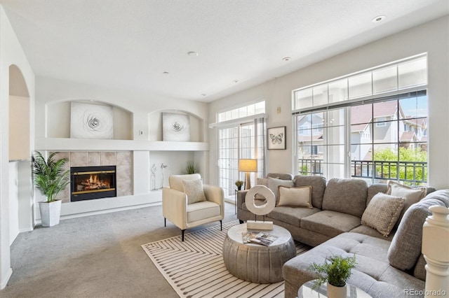 living area with recessed lighting, built in shelves, carpet, and a tile fireplace