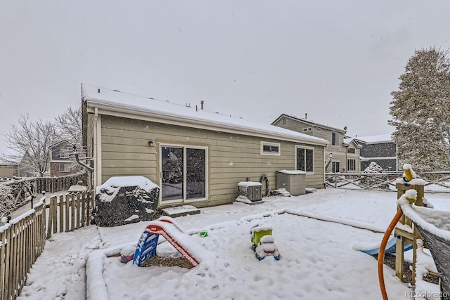 snow covered house featuring fence