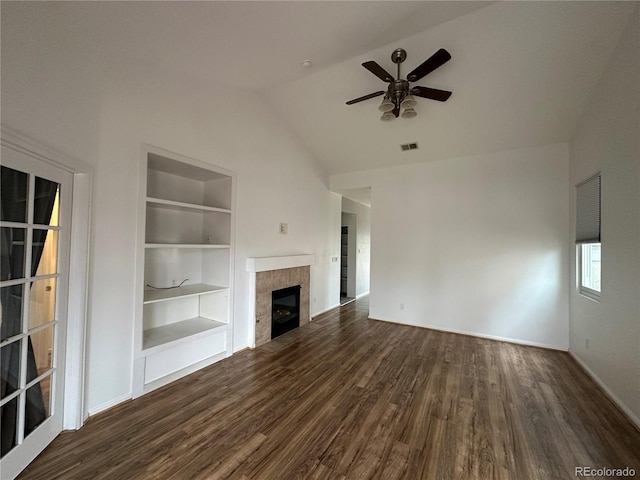 unfurnished living room featuring visible vents, a tiled fireplace, dark wood-style flooring, vaulted ceiling, and built in shelves