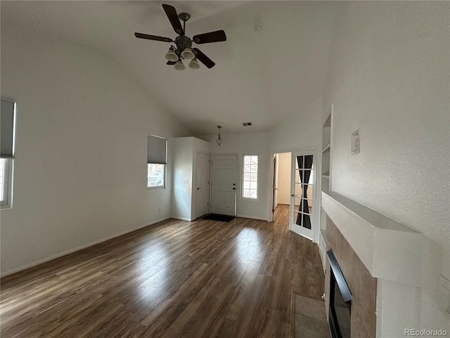 unfurnished living room featuring plenty of natural light, visible vents, ceiling fan, and dark wood-style flooring