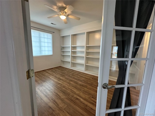 empty room featuring a ceiling fan, visible vents, wood finished floors, and french doors