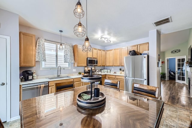 kitchen with light brown cabinets, stainless steel appliances, a sink, and visible vents