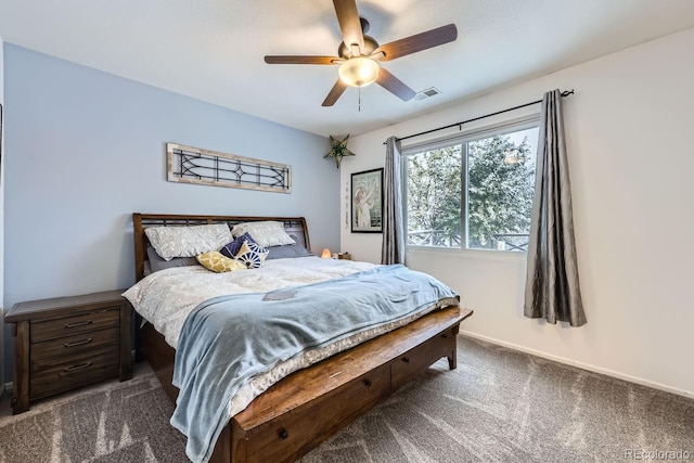 bedroom with a ceiling fan, dark carpet, visible vents, and baseboards