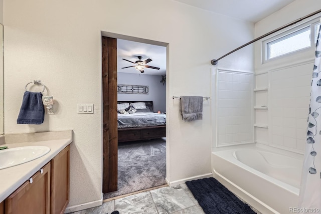 ensuite bathroom featuring shower / tub combo with curtain, connected bathroom, vanity, ceiling fan, and baseboards