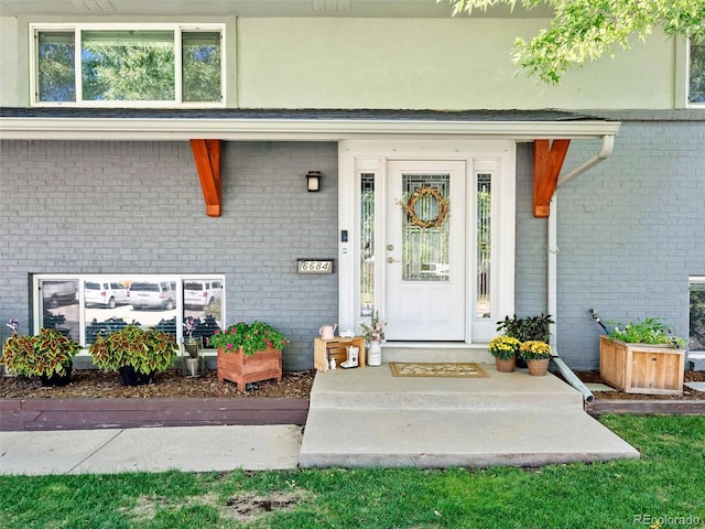 doorway to property featuring brick siding