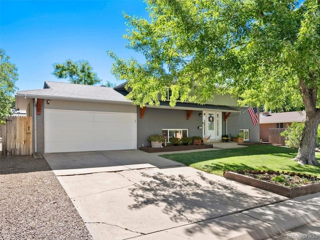 view of front facade with brick siding, concrete driveway, an attached garage, a front yard, and fence