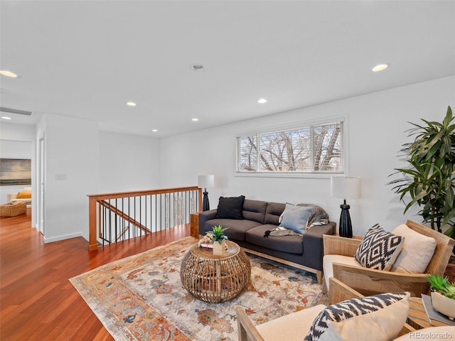 living room with recessed lighting, visible vents, baseboards, and wood finished floors