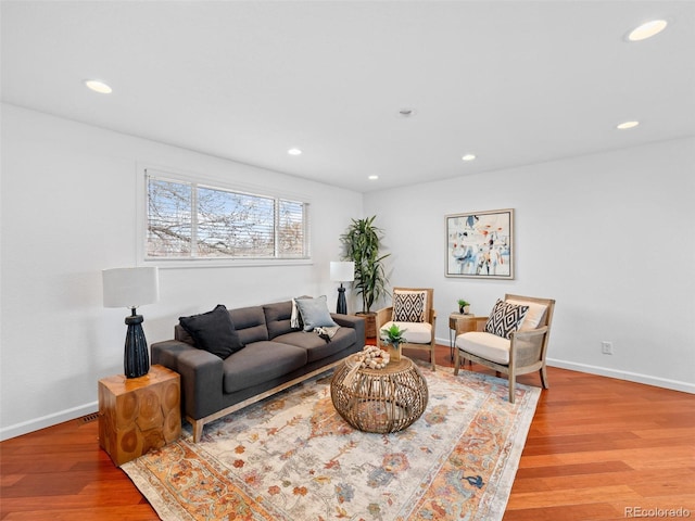 living room with recessed lighting, baseboards, and wood finished floors