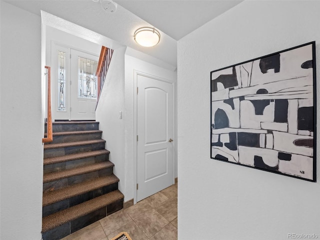 stairway featuring tile patterned flooring