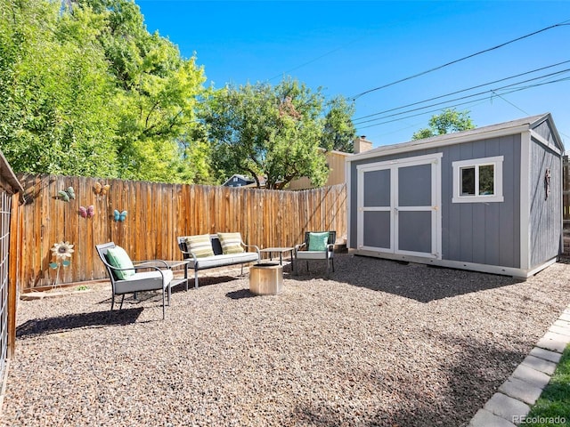 view of yard featuring a fenced backyard, a storage unit, and an outbuilding