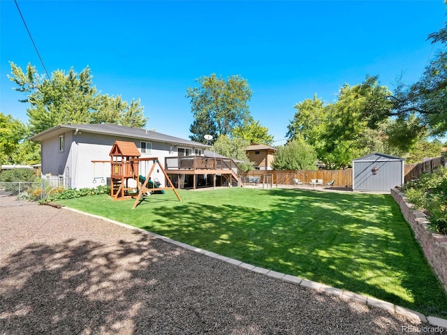 view of yard featuring a playground, a shed, an outdoor structure, and a fenced backyard