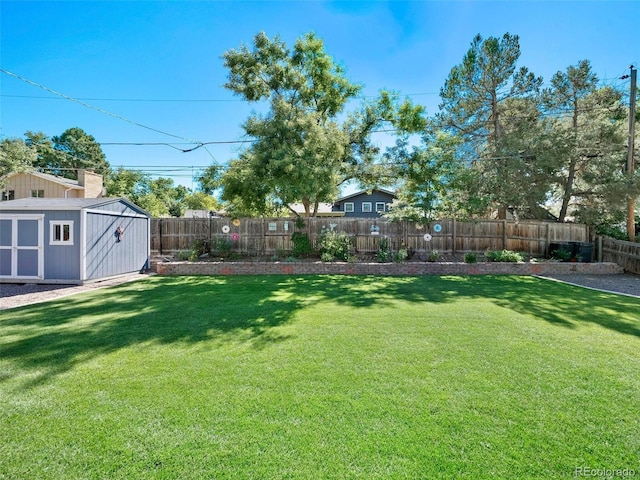 view of yard with an outbuilding, a fenced backyard, and a storage unit