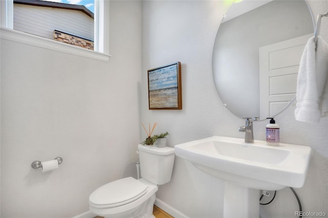 bathroom featuring toilet and baseboards