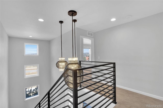 stairway featuring plenty of natural light, baseboards, and recessed lighting