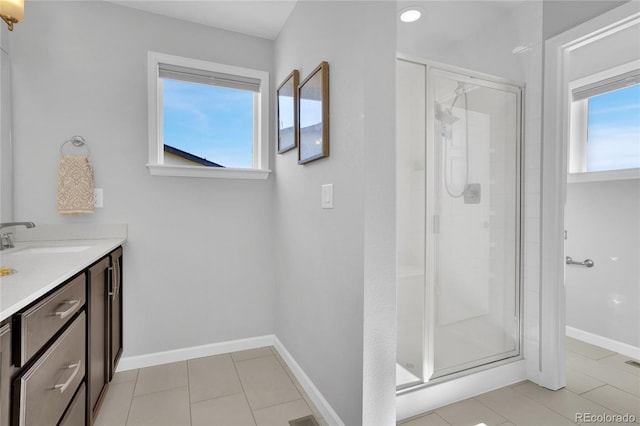 bathroom with tile patterned floors, a shower stall, baseboards, and vanity