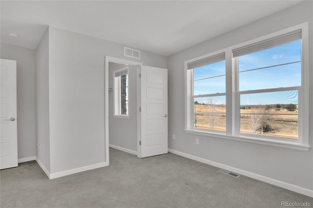 unfurnished bedroom with carpet floors, visible vents, and baseboards