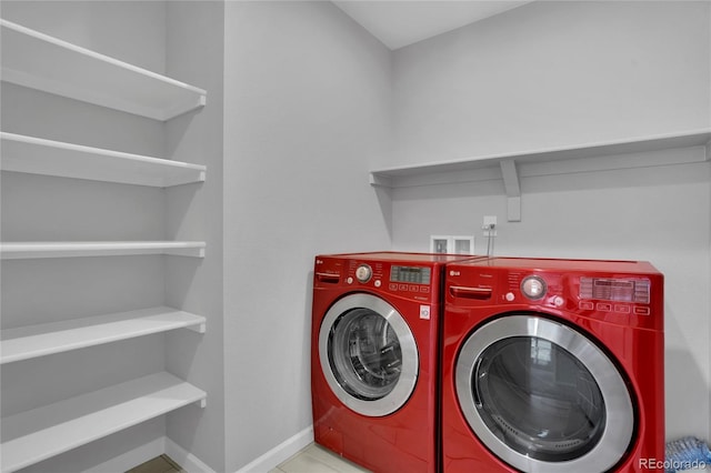 washroom with laundry area, baseboards, and washer and dryer