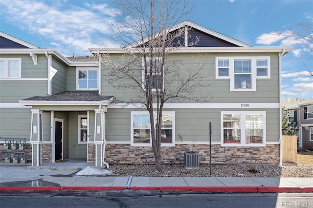 view of front of property with stone siding and central AC