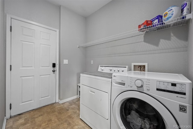 washroom featuring laundry area, washer and clothes dryer, and baseboards