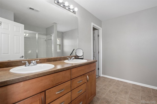 bathroom featuring double vanity, a sink, visible vents, and a shower stall