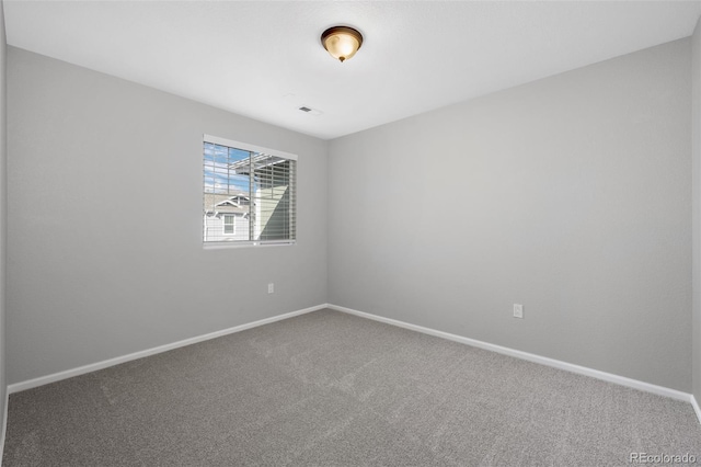 spare room featuring carpet and baseboards