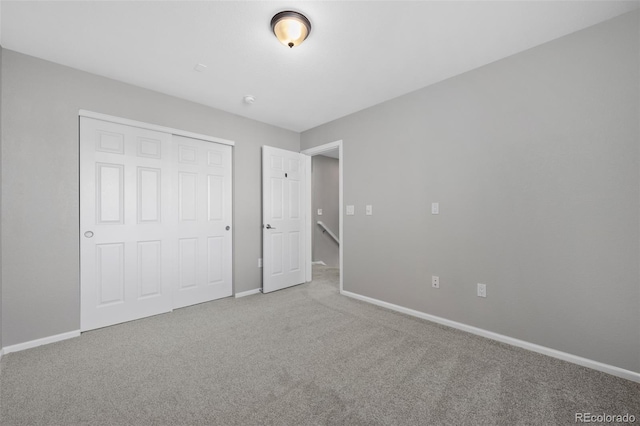 unfurnished bedroom with carpet floors, a closet, and baseboards