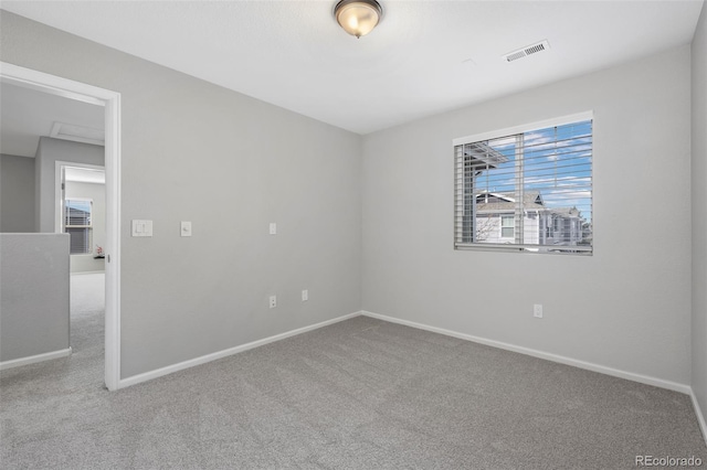 spare room with carpet, visible vents, and baseboards