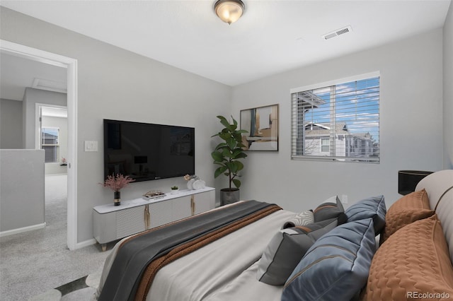 carpeted bedroom with visible vents and baseboards