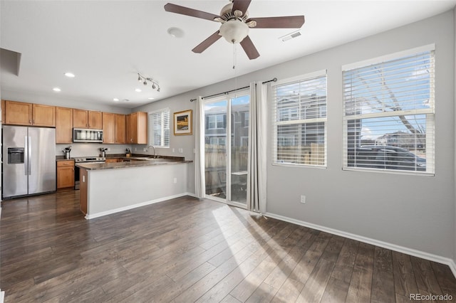 kitchen featuring dark wood-style flooring, dark countertops, visible vents, appliances with stainless steel finishes, and baseboards