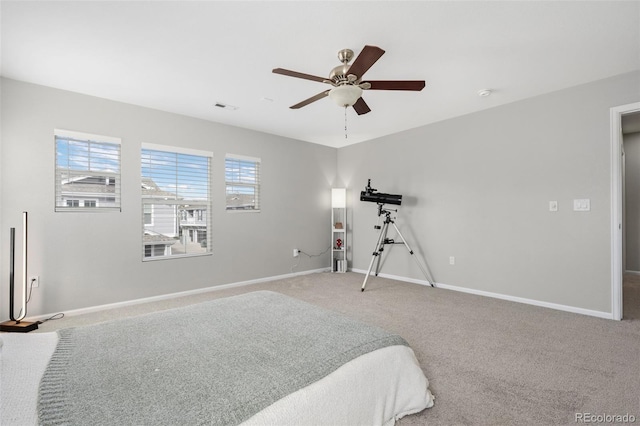 carpeted bedroom featuring baseboards, visible vents, and ceiling fan