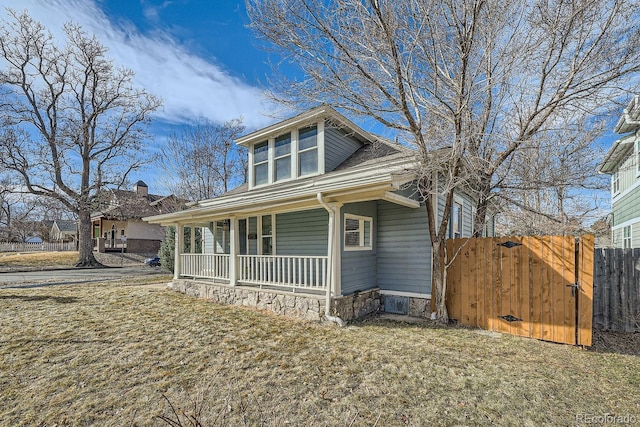 bungalow with a gate, fence, a porch, and a front yard