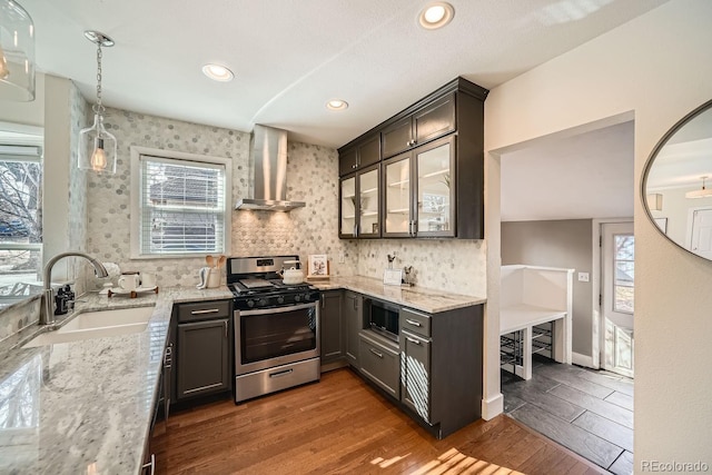 5101 Meade St, Denver, CO 80221 - kitchen featuring wood finished floors, a sink, wall chimney exhaust hood, stainless steel appliances, and light stone counters