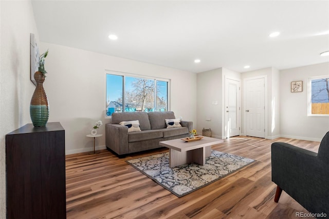 living area with light wood-style floors, recessed lighting, and baseboards