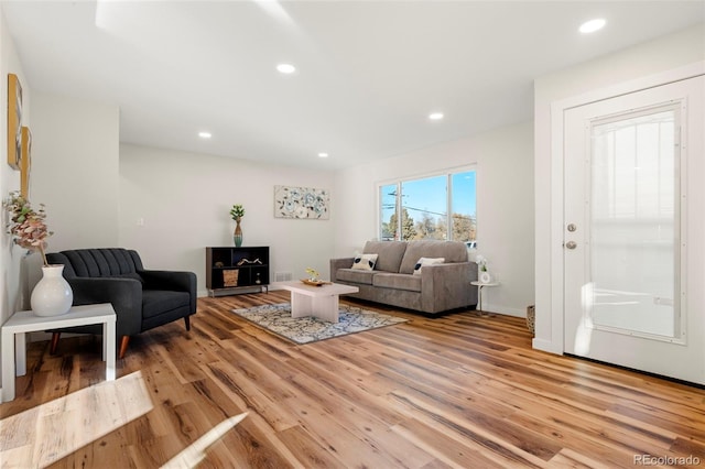 living room with light wood-type flooring, baseboards, and recessed lighting