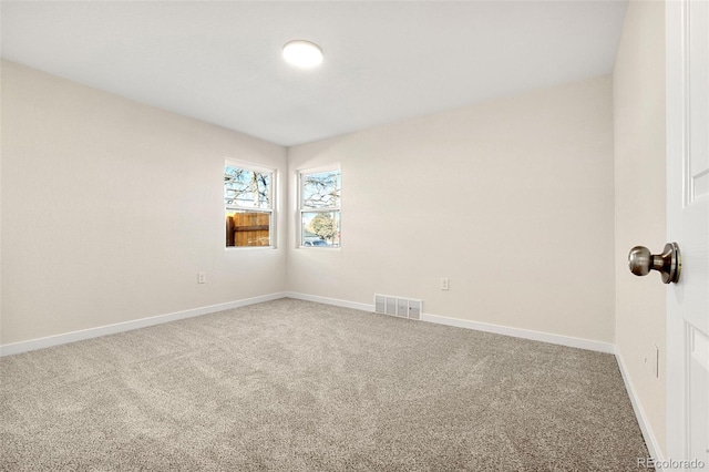 empty room with baseboards, visible vents, and carpet flooring