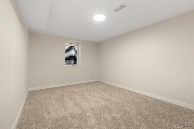 carpeted empty room featuring visible vents and baseboards