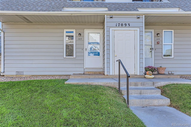 property entrance with a lawn