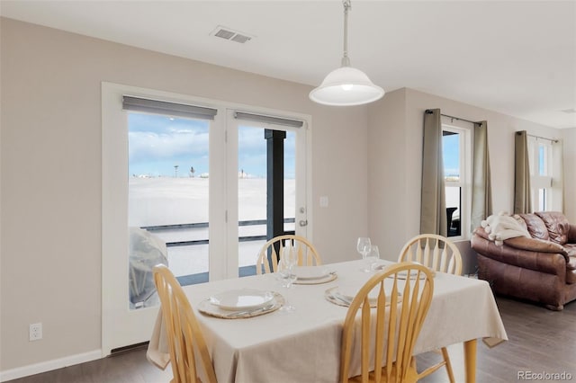 dining room featuring wood finished floors, visible vents, and baseboards