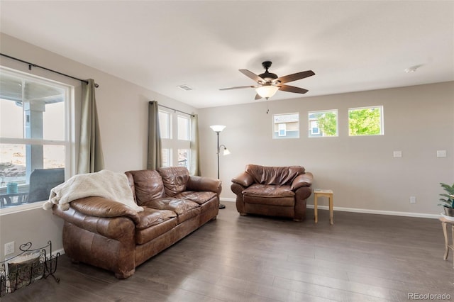 living area with plenty of natural light, baseboards, and wood finished floors