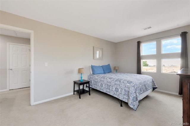 bedroom with light carpet, attic access, visible vents, and baseboards