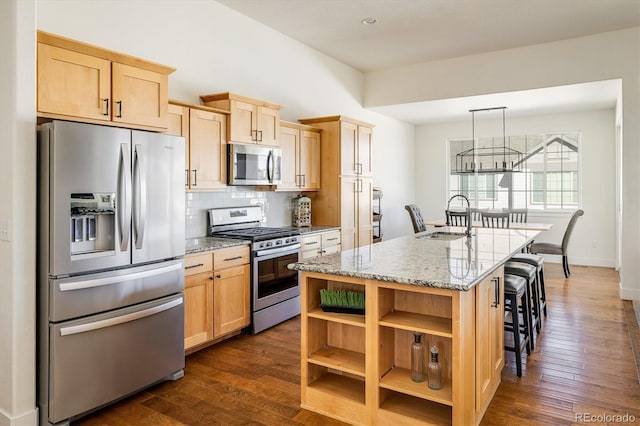 kitchen with sink, light stone counters, tasteful backsplash, a center island with sink, and stainless steel appliances