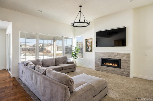 carpeted living room with a chandelier and a tiled fireplace