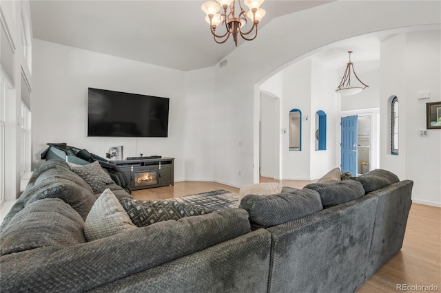 1510 S De Gaulle Cir, Aurora, CO 80018 - living area featuring arched walkways, wood finished floors, a chandelier, baseboards, and healthy amount of natural light
